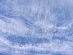 Blue sky with wispy white clouds.