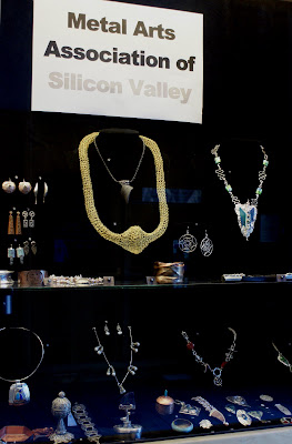 Arrow C Glass necklace just below the sign inside the gold-wire necklace