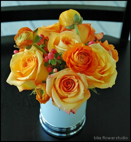 Latin Beauty' roses orange ranunculus and peach hypericum berries in a 