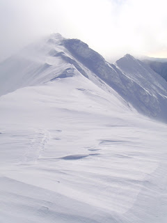 トヨニ岳の細い頂を西から東へ風が吹き抜けていく。稜線上の吹きだまりが左右に交互に出てノコギリ状になっている。