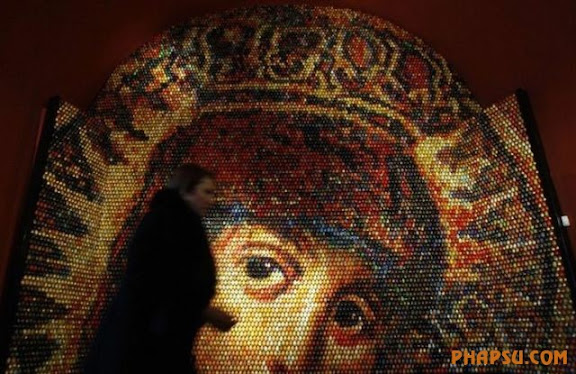 A woman walks past a mosaic of the Virgin Mary during its unveiling ceremony in Kiev January 13, 2010. The artwork, created by Ukrainian artist Oksana Mas, is made from 15,000 painted Easter eggs. REUTERS/Stringer (UKRAINE - Tags: SOCIETY RELIGION)