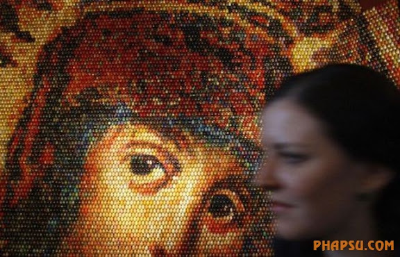 A woman walks past a mosaic of the Virgin Mary during its unveiling ceremony in Kiev January 13, 2010. The artwork, created by Ukrainian artist Oksana Mas, is made from 15,000 painted Easter eggs. REUTERS/Stringer (UKRAINE - Tags: SOCIETY RELIGION)