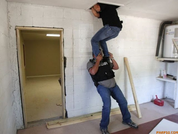 RNPS IMAGES OF THE YEAR 2009 - A member of the Hidalgo County Gang Enforcement Unit boosts his partner into an attic space as they search for a hand gun used in a gang related murder on an evidentiary search warrant in Edinburg, Texas, in this April 14, 2009 file photo. Gangs and their culture of violence, drugs and crime are one of America's pressing social ills. But in the borderlands the problem has an urgency that has federal investigators worried. To match feature USA-GANGS/BORDER     REUTERS/Jessica Rinaldi/Files   (UNITED STATES CONFLICT SOCIETY POLITICS)