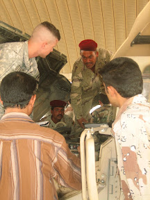 SPC Brady Singleton instructs Iraqi Soldiers assigned to the 10th Motorized Transportation Regiment, on preventive maintenance checks and services on a humvee recently. (U.S. Army photo by Lt. Monica Colgan)