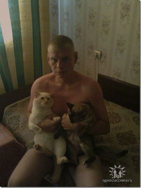 Naked man holding two cats