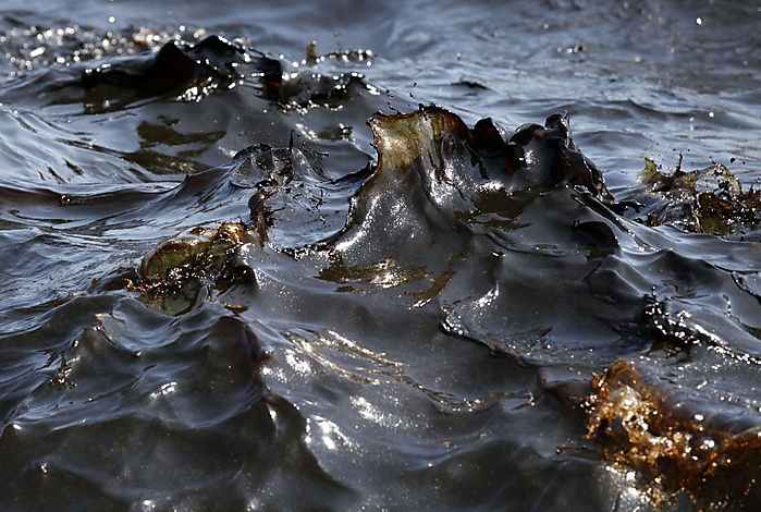 Thick black waves of oil and brown whitecaps are seen off the side of the supply vessel Joe Griffin at the site of the Deepwater Horizon oil spill containment efforts in the Gulf of Mexico off the coast of Lousiana Sunday, May 9, 2010. (AP Photo / Gerald Herbert)