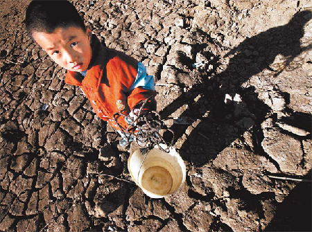An unidentified boy carries a bucket to collect water in Changkou town in Kunming, Yunnan province. The drought, the worst in 60 years, has affected 3.39 million people and 1.14 million hectares of cropland in Yunnan and the Guangxi Zhuang autonomous region. Photo / Wang Yuheng
