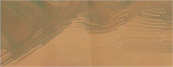 Shrimp trawlers, and their mudtrails, off the coast of the Jiangsu Province of China near the mouth of the Yangtze River in 2003. QuickBird satellite via Google Earth