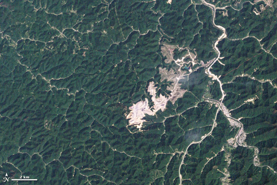 Mountaintop removal in Boone County, West Virginia. The images show forests being stripped, valleys filled, and giant craters excavated in the process of mining thin seams of coal at Hobet mine. NASA Earth Observatory