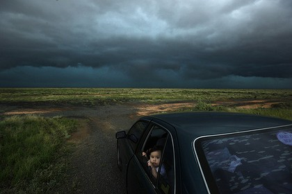 Should I wind up the window, Mum? … Jimelle Deguara watches a hailstorm break over the Hay region in New South Wales. Photo: Nick Moir