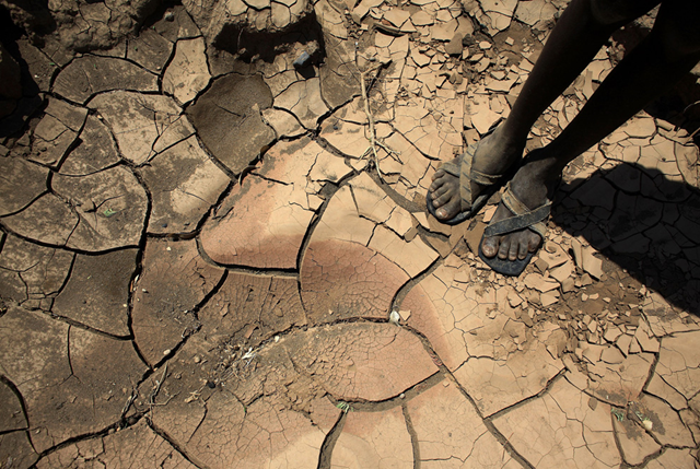 A young boy from the Turkana tribe stands on a dried up riverbed on November 9, 2009 near Lodwar, Kenya. (Christopher Furlong / Getty Images)