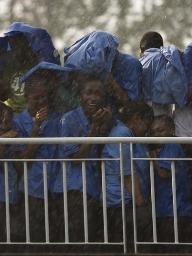 Faithful stand in the rain listening to Pope Benedict XVI as he delivers a sermon at the basilica in Cameroon's capital Yaounde on March 18, 2009. Cameroon has seen increasingly strong rainfall in the early months of each year, normally its dry period. REUTERS / Finbarr O'Reilly