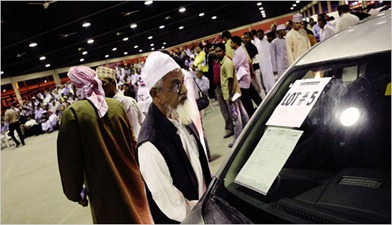 A prospective bidder examined a car on Wednesday at a Dubai auction. Debt-ridden foreigners are selling or abandoning cars. (Bryan Denton for The New York Times) 