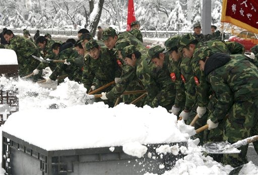 In this photo taken Thursday, Nov. 12, 2009, soldiers of the militia, a civilian reserve force under China's military, shovel snow on the road in Taiyuan, in north China's Shanxi province. Heavy snow and blizzards wiped north China, caused several death and hundreds of injuries, State media reported. (AP Photo)