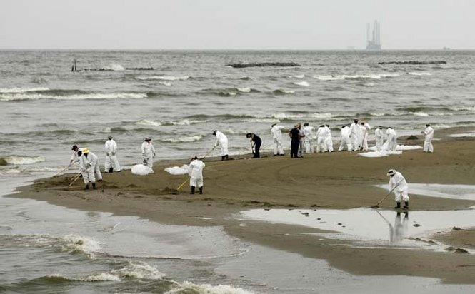 Clean up workers tackle the oil washed up on the beach at Grand Isle State Park Thursday, June 3, 2010. Steady blobs of oil, some two feet wide, came in on the beach throughout the day. SUSAN POAG / THE TIMES-PICAYUNE