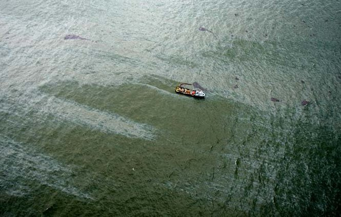 An oilfield workboat uses a oil containment boom to collect oil floating as far as the eye can see off the coast of Grand Isle, , La., as the crude makes landfall on Louisiana's barrier island beaches and inundates Barataria Bay, even as oil continues to spew from the Deepwater Horizon spill into the Gulf of Mexico, Wednesday, June 2, 2010. PHOTO BY TED JACKSON / THE TIMES-PICAYUNE