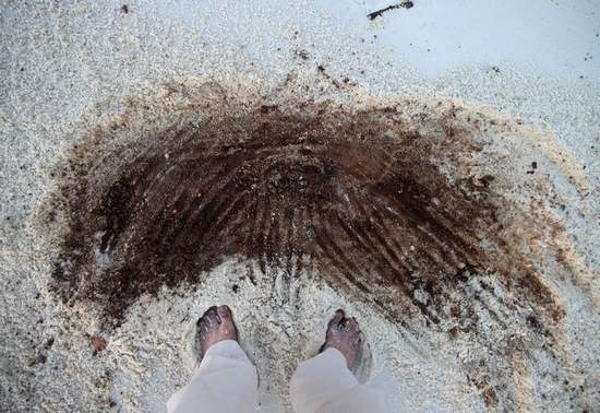 A section of beach across from Peg Leg Pete's that was contaminated with thick tar and oil on Wednesday appeared to have been cleaned by contractors overnight. But Thursday evening a News Journal reporter found much of the oil from the previous day was buried by the high tide Wednesday night and remained just an inches beneath the surface. Travis Griggs / tgriggs@pnj.com