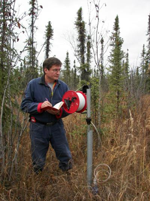 University of Alaska Fairbanks Professor Vladimir Romanovsky measures permafrost temperature at a borehole in interior Alaska. Credit: Photo by A. Kholodov