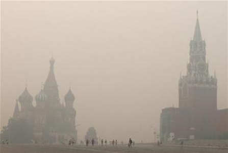 Lone tourists walk along Red Square in heavy smog, caused by peat fires in nearby forests, in central Moscow August 9, 2010. REUTERS / Alexander Demianchuk