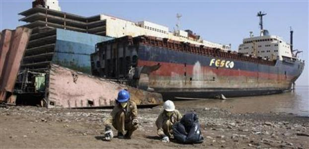 Workers collect metal scraps from a decommissioned ship at the Alang shipyard, about 260 km (162 miles) west from the western Indian city of Ahmedabad, February 25, 2009. Reuters / Amit Dave