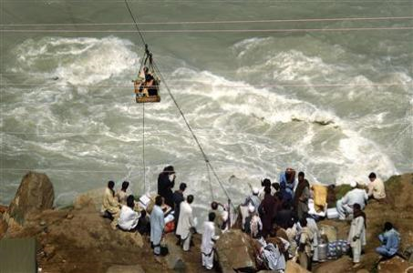 People cross the Swat River on a zipline after a bridge was washed away by floods near Madyan in Pakistan's Swat Valley August 27, 2010. Reuters / Tim Wimborne