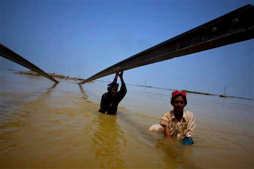 People use a damaged railway track to cross heavy floodwater in Sultan Kot, in southern Pakistan on Saturday, Aug. 28, 2010. According to the United Nations, almost 17.2 million people have been significantly affected by the floods and about 1.2 million homes have been destroyed or badly damaged. The floods began almost a month ago with the onset of the monsoon and have ravaged a massive swath of Pakistan. AP Photo / Anjum Naveed