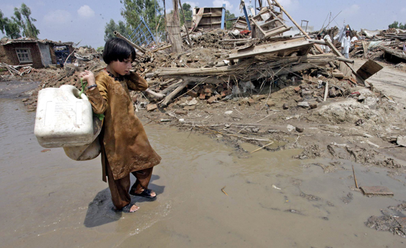 A young flood survivor walks in search of clean water in Nowshera near Peshawar, Pakistan. Mohammad Sajjad / Associated Press / cbc.ca