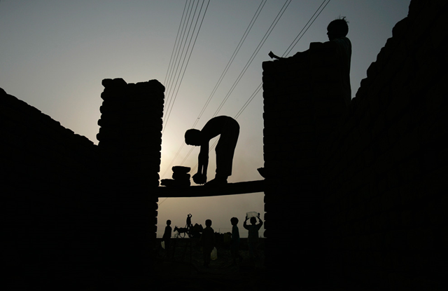 A boy helps his father rebuild their flood-damaged house in Muzaffargarh district, Punjab province, Pakistan on Tuesday Aug. 31, 2010. AP Photo / Aaron Favila