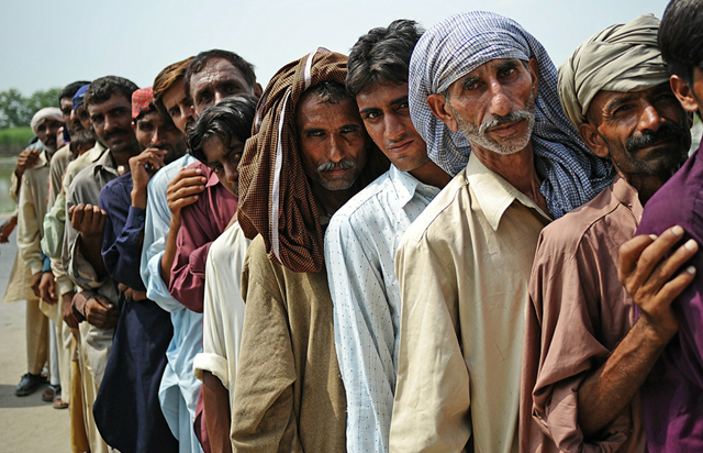 Flood victims queue for aid provided by Sitara Chemical Industries Ltd in Sanawan, Punjab province Pakistan, on September 5, 2010. CARL DE SOUZA / AFP / Getty Images