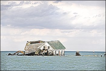 A storm in October 2010 dealt a crippling blow to the last building on Holland Island in Chesapeake Bay, a remnant of a once-thriving town. Rising sea level has claimed the island. Photo: Astrid Riecken