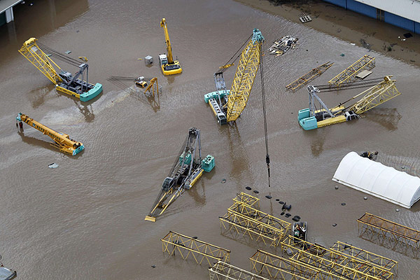 Cranes submerged by floodwaters in an industrial area of Brisbane on January 13, 2011. REUTERS / Tim Wimborne
