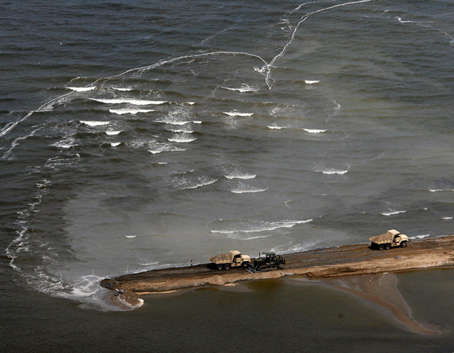 In May 2010, military vehicles dump material as they build a berm across an opening in the beach just west of Grand Isle in an effort to protect the delicate marsh from the approaching oil slick from the Deepwater Horizon spill. Ted Jackson, Times-Picayune archive