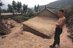 FROM HIS ROOFTOP, Su Rongxi maintains an unsteady balance, perched between the past and a precarious future. One foot is planted firmly upon his tiled roof. The other sinks ankle-deep into a huge sand dune that threatens to engulf his house and Langtougou village, where his ancestors have lived for generations. gluckman.com