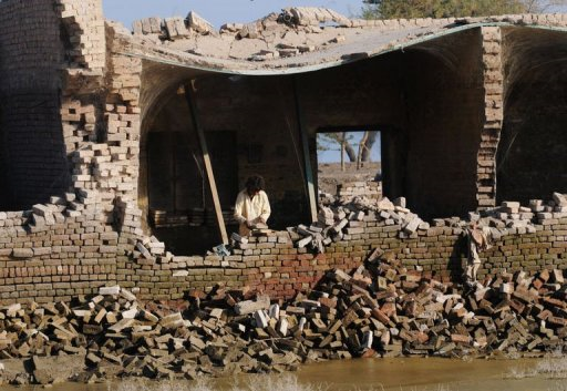 A Pakistani boy stands in his destroyed house. AFP