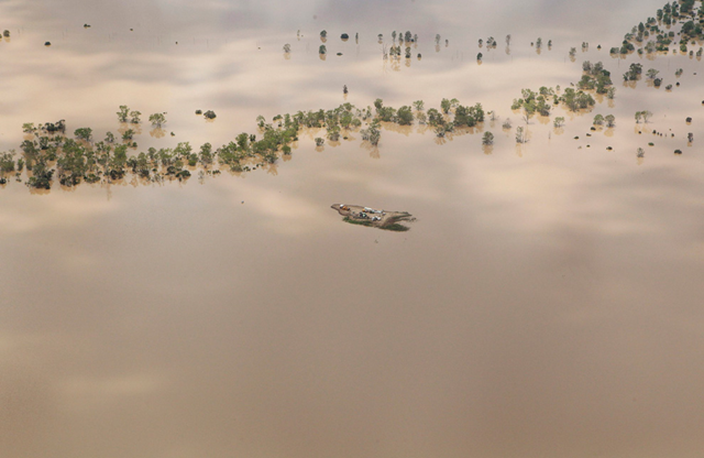 Agricultural machinery is seen on an isolated island surrounded by flood waters near the town of Emerald in Australia's state of Queensland January 2, 2011. REUTERS / Daniel Munoz
