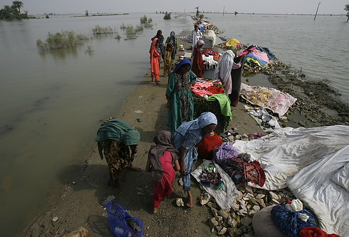Women dry clothes on a road partially submerged by floodwaters in Karampur, Pakistan, Aug. 30, 2010. Athar Hussain / Reuters
