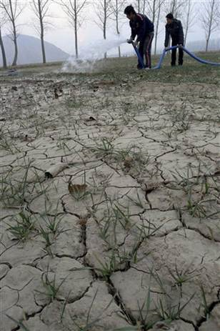 In this photo taken Saturday Feb. 5, 2011, Chinese farmers water a dried up plot of wheat near Huaibei city in central China's Anhui province. China is sending relief teams to eight drought affected provinces that grow more than two-thirds of the country's wheat. (AP Photo) CHINA OUT