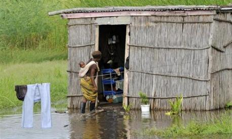 A woman enters her home flooded with water, close to the swollen Limpopo River in Mozambique, on January 25, 2011. REUTERS / Grant Lee Neuenburg