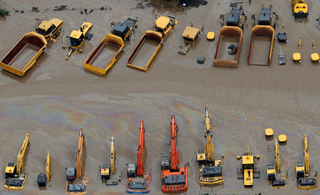 Heavy equipment sits submerged in flood waters in an industrial area of Brisbane, Australia, on January 13, 2011. Flood water in Australia's third-biggest city peaked below feared catastrophic levels on Thursday but Brisbane and other devastated regions face years of rebuilding and even the threat of fresh floods in the weeks ahead. REUTERS / Tim Wimborne