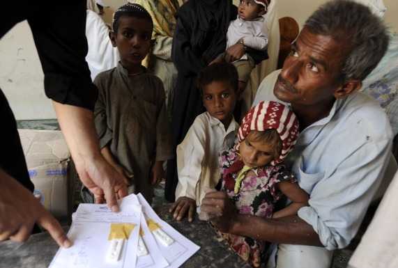 Usman Chamdia's and his four children have malaria symptoms. So far, three tests have come back positive. By the end of the morning, tests will determine that all five family members are infected. Chamdia brought four of his six children to the Merlin mobile health clinic, held in a defunct school building in the small village of Basti Allah Wali. The community is located near the banks of the Indus River and has been hard-hit by floods and the malaria season. Jacqueline Koch / Merlin