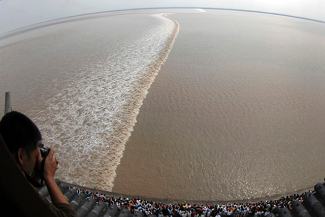 Visitors gather to watch the soaring tide on the bank of Qiantang River in Haining, Zhejiang province, October 6, 2009. The most violent tidal waves are seen each year along the river during the eighteenth day of the eighth month of the Chinese Lunar calendar, which falls on October 6 this year. REUTERS / Stringer / CHINA ENVIRONMENT SOCIETY