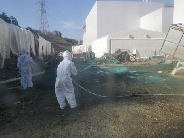 A TEPCO worker sprays chemical hardening agent around the Fukushima Daiichi nuclear plant, 18 April 2011. TEPCO / japannewstoday.com