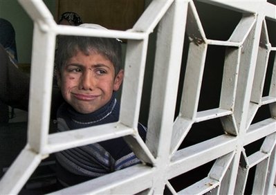A Palestinian child, wounded earlier in an Israeli military attack, is seen through the window of Kamal Edwan hospital of the northern Gaza Strip town of Beit Lahiya, Wednesday, Jan. 14, 2009. Israel showed no signs of slowing its bruising 19-day offensive against Gaza's Hamas rulers, striking some 60 targets on Wednesday. Israel launched the onslaught on Dec. 27, seeking to punish the Hamas militant group for years of rocket attacks on southern Israel. The offensive has killed more than 940 Palestinians, half of them civilians, according to Palestinian hospital officials. (AP Photo/Majed Hamdan)