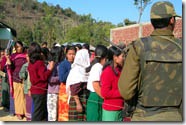 A security personnel stands guard as the voters stand in queue for voting in a polling station in Kotlenphai under Tengnoupal constituency in Chandel district of Manipur. Chandel, Churachandpur and Tamenglong districts and Jiribam sub-division of Imphal-East district of Manipur go on poll on the third and final phase of Manipur Legislative Assembly.
Photo: Ph. Santosh PTI Imphal.
          