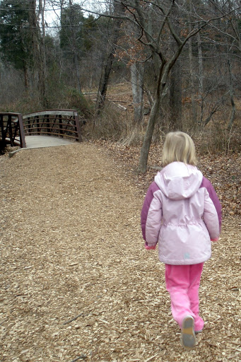 Meg walking down a path through the woods.