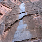 Water runs down the side of a gigantic rock at the “Temple of Sinawava” in Zion