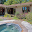 The outdoor area features a jacuzzi set amongst a flower garden.