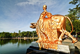 Woman with buffalo sculpture on the right side of the lagoon.