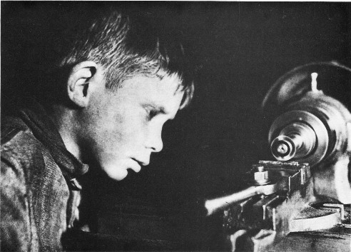 K. Kuznetsov: Young communards working in the Dzerzhinsky Commune machine shop in 1934. (From 'USSR in Construction', April 1934.)