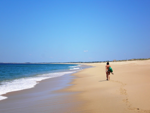 Mulher caminhando pela praia do Carvalhal